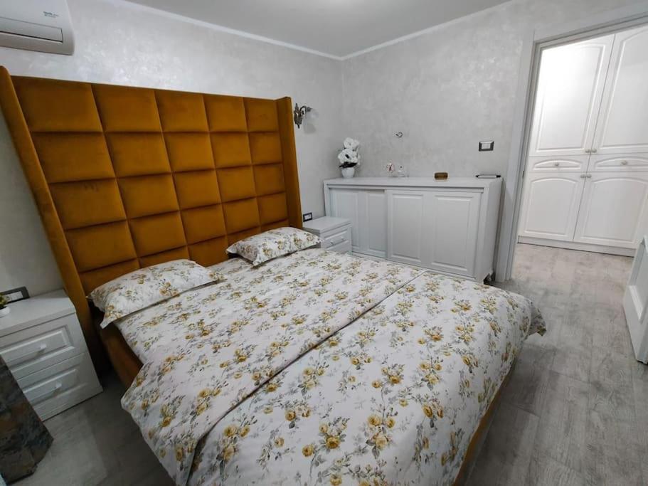 1 dormitorio con 1 cama grande y cabecero grande en Apartament Bzg 1 en Rădăuţi