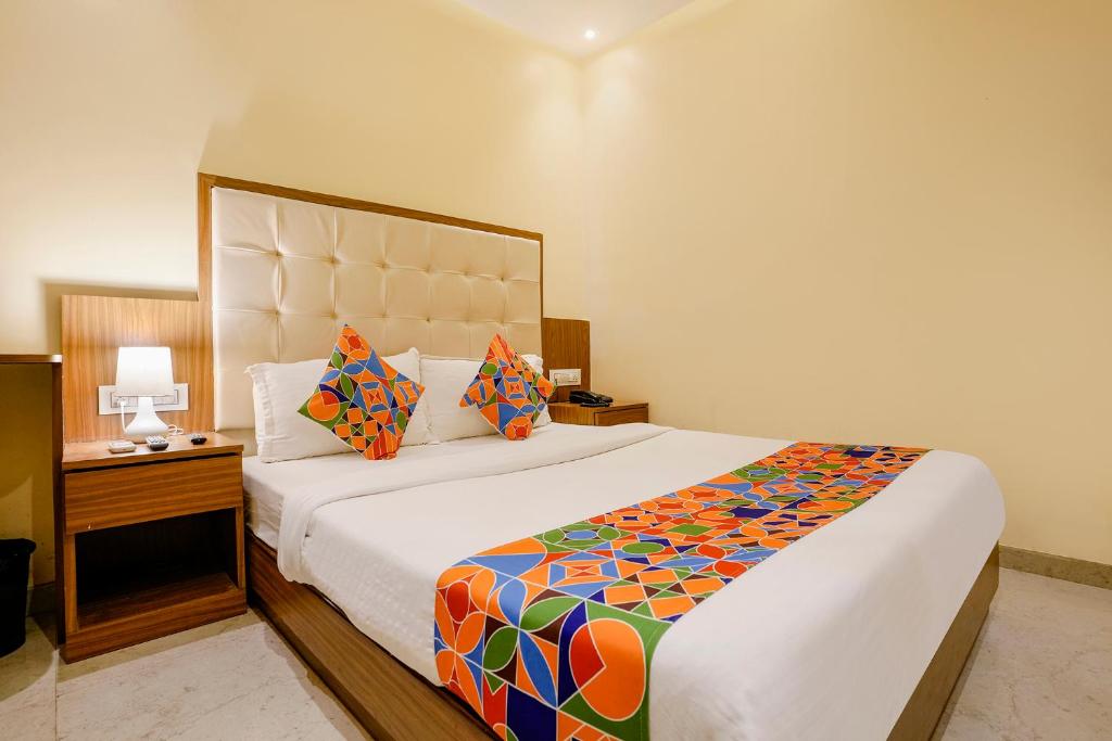 a bedroom with a large bed with a colorful blanket at FabExpress Wynd in Mumbai