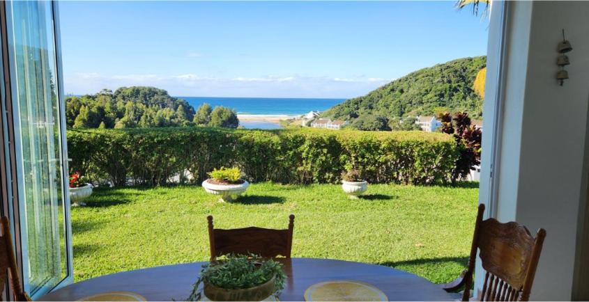 a room with a table and a view of the ocean at The Estuary Country Estate, Villa "Once Upon A Tide" in Port Edward