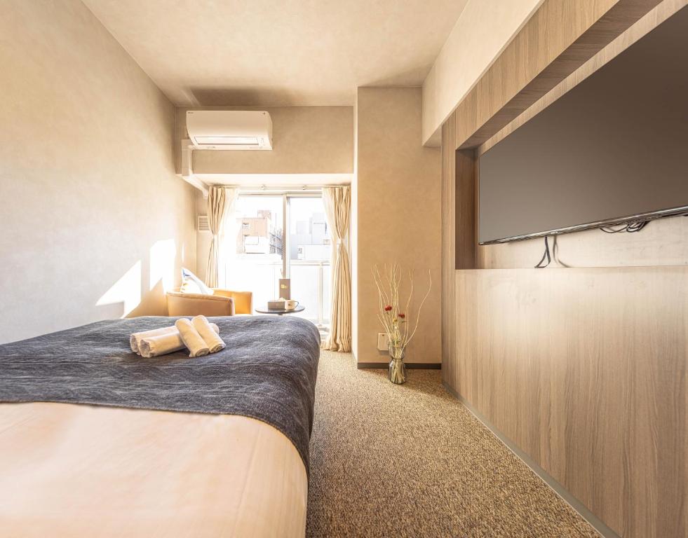 a bedroom with a bed and a flat screen tv at Apartment Hotel 11 Shinsaibashi II in Osaka