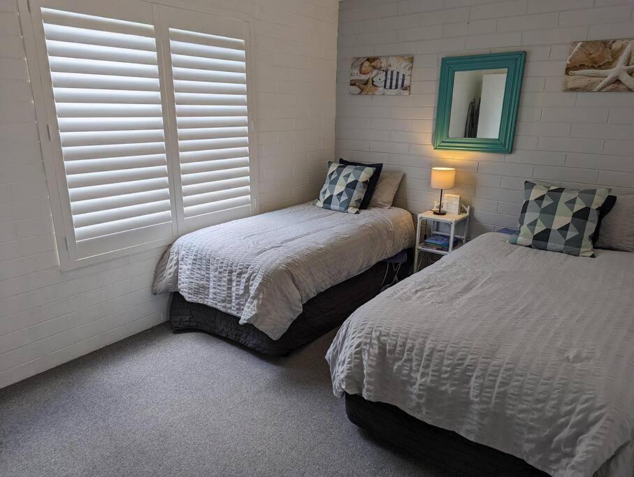a bedroom with two beds and a mirror at Totally Beachin! - walking distance to the beach in Eden
