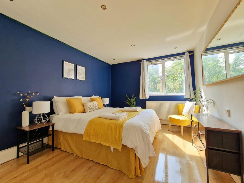 a bedroom with a large bed with a blue wall at Paddington in London