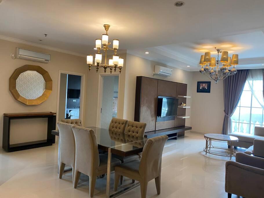 a dining room and living room with a table and chairs at Lovely 3-Bedroom rental unit in Jakarta