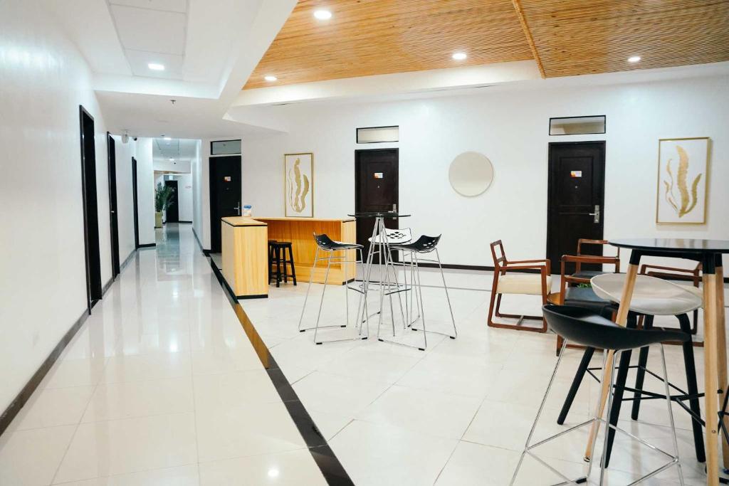 a living room with tables and chairs in it at Travelbee Airport Inn in Mactan