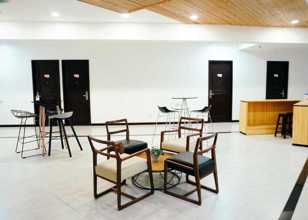 a room with chairs and a table and a counter at Travelbee Airport Inn in Mactan