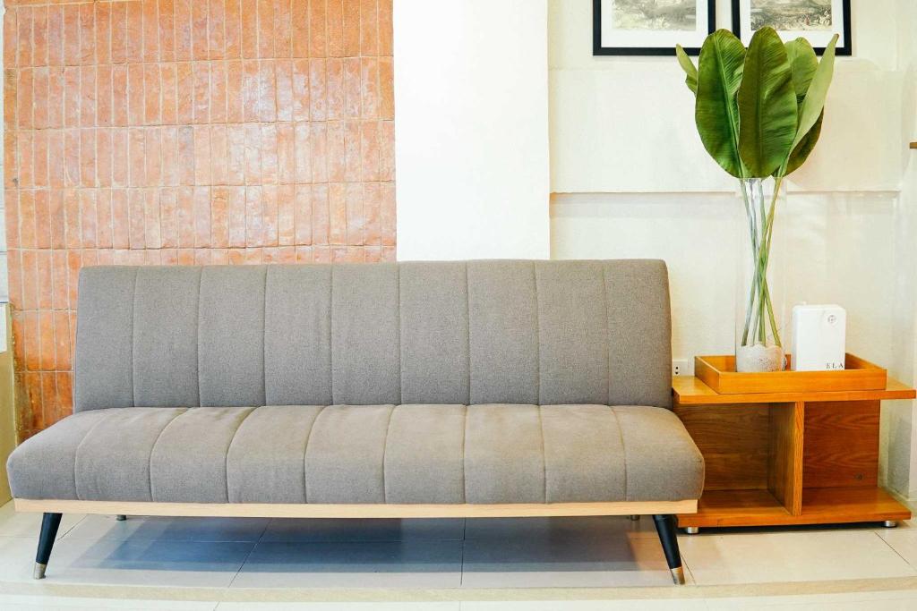 a gray couch in a room with a table at Travelbee Airport Inn in Mactan
