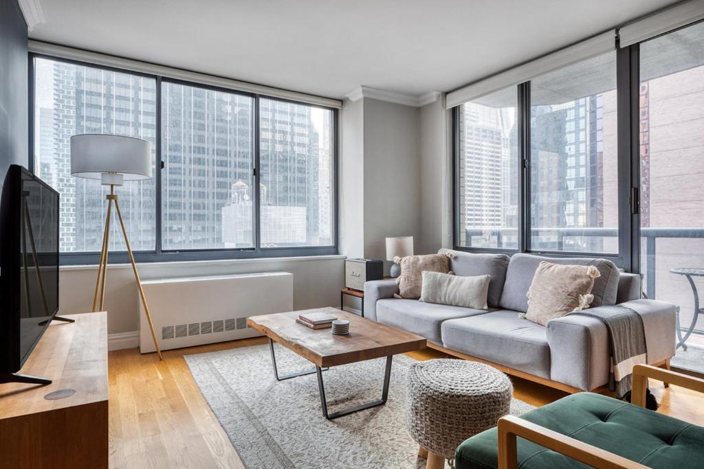 a living room with a couch and a table at Midtown 1BR w Water views Indoor pool NYC-36 in New York