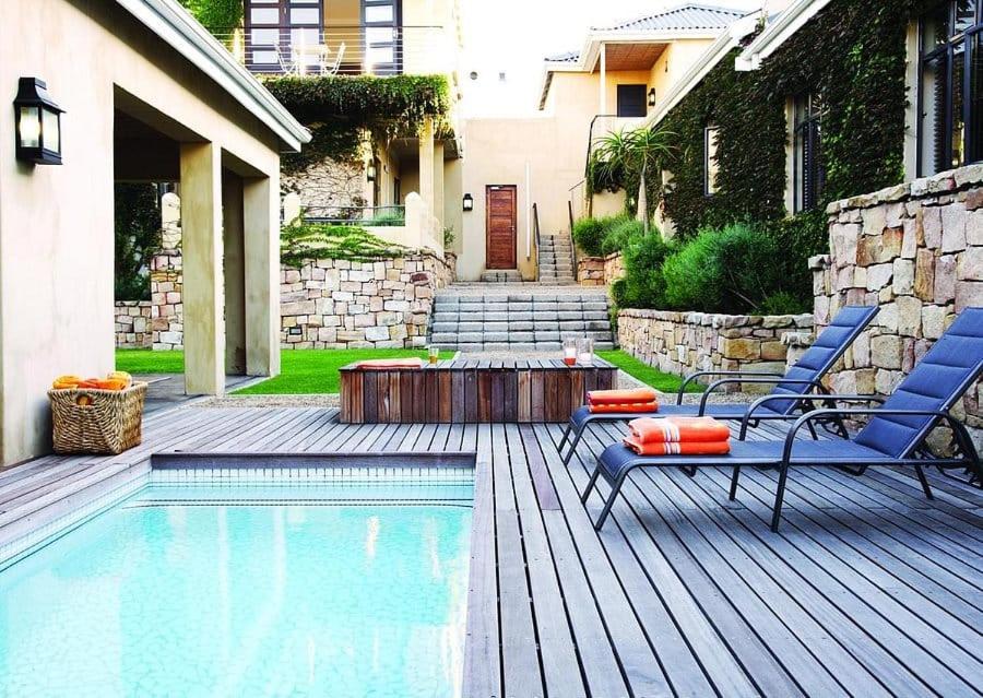 uma piscina com duas cadeiras e uma mesa ao lado de uma casa em The Windermere Hotel em Summerstrand
