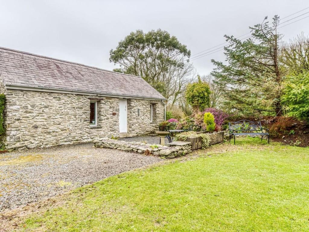 a stone house with a garden in front of it at Secluded Holiday Home in Ceredigion with Garden in Pennant