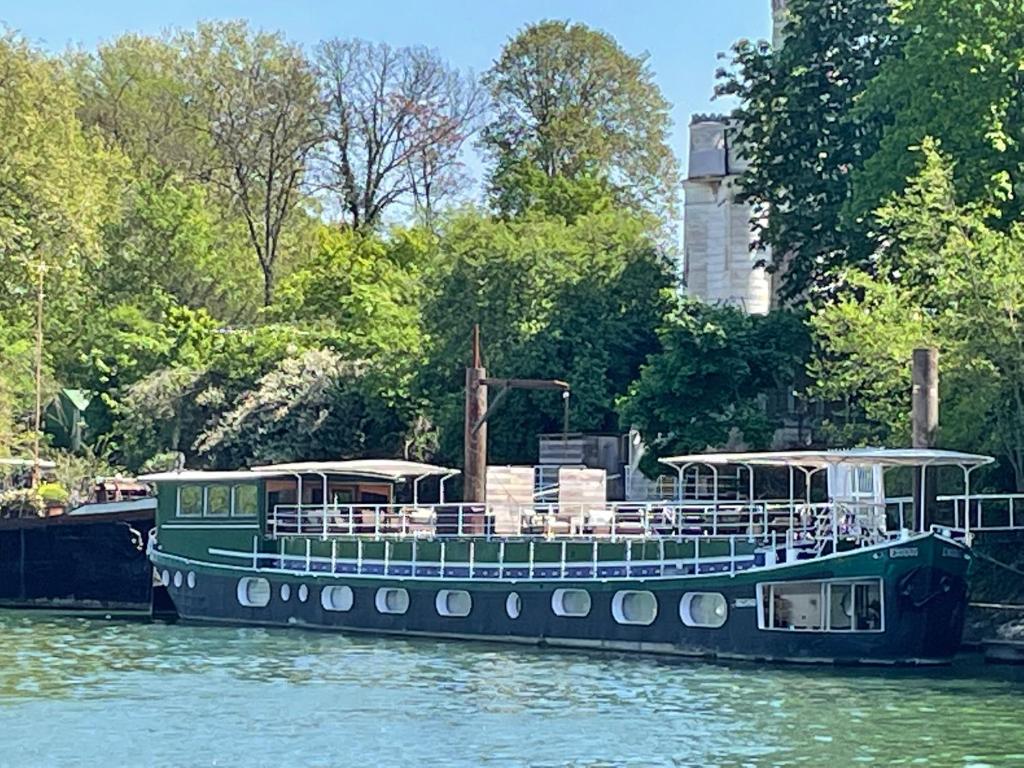 a green boat is docked on the water at Escale Sur Seine in Paris
