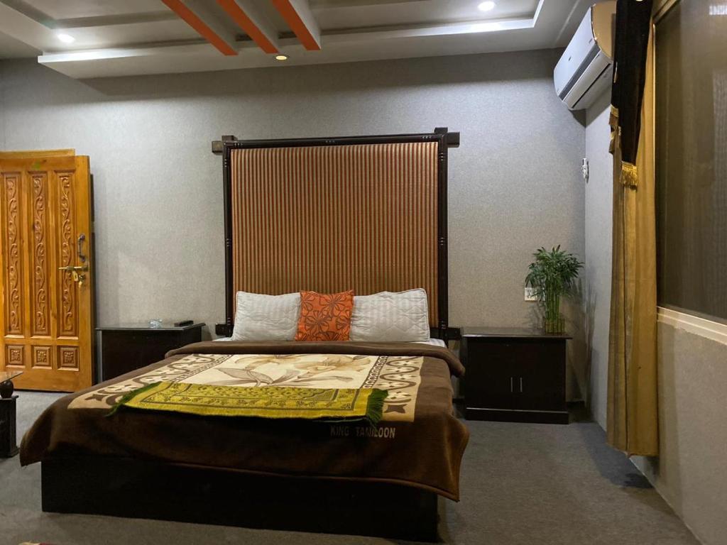 a bedroom with a bed with a large headboard at Kashmir lodge in Muzaffarabad