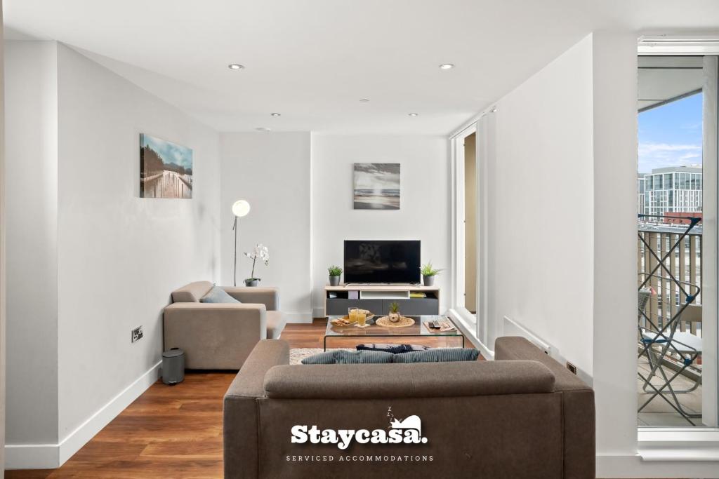 a living room with a couch and a tv at Spectacular Apartment Balcony View In City Centre in Manchester