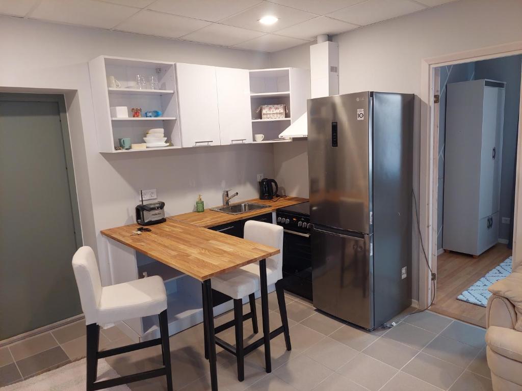 a kitchen with a wooden table and a refrigerator at Elva Arbimäe apartment in Elva