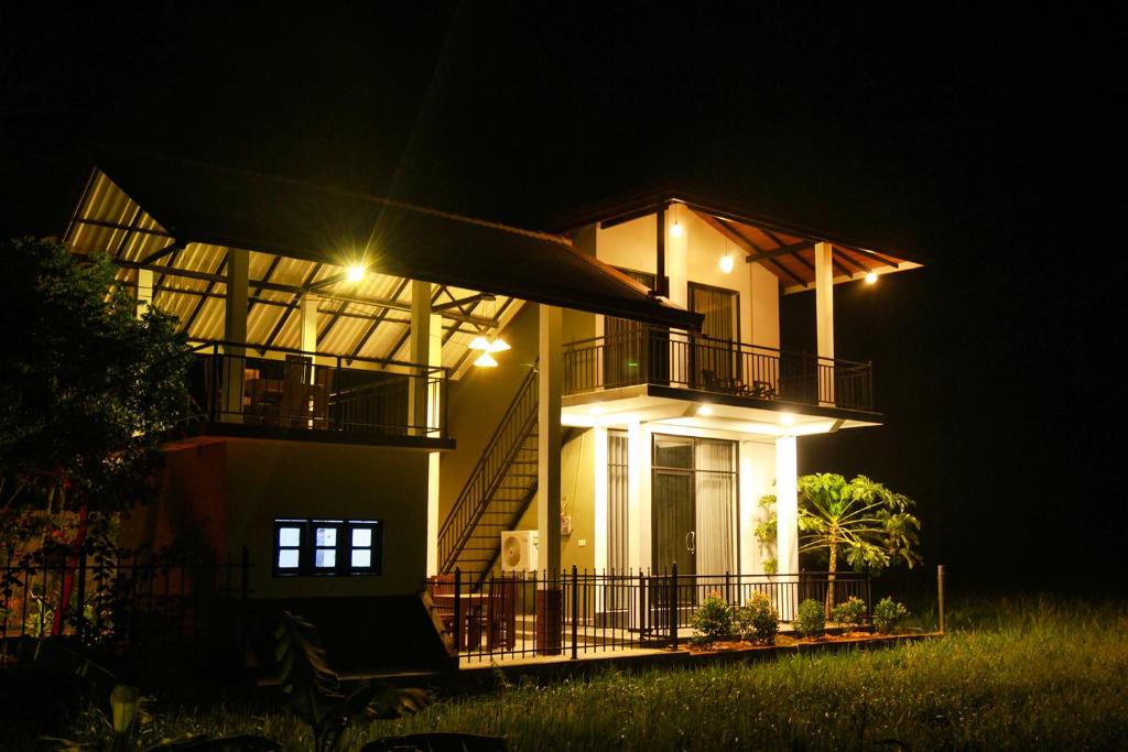 a house lit up at night with lights at Oragan Resort in Tissamaharama