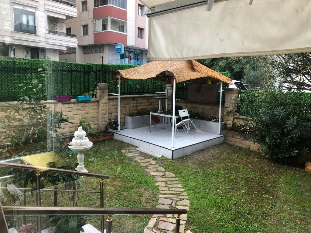 - un petit jardin avec une table et un parasol dans l'établissement Göl Otel, à Avcılar