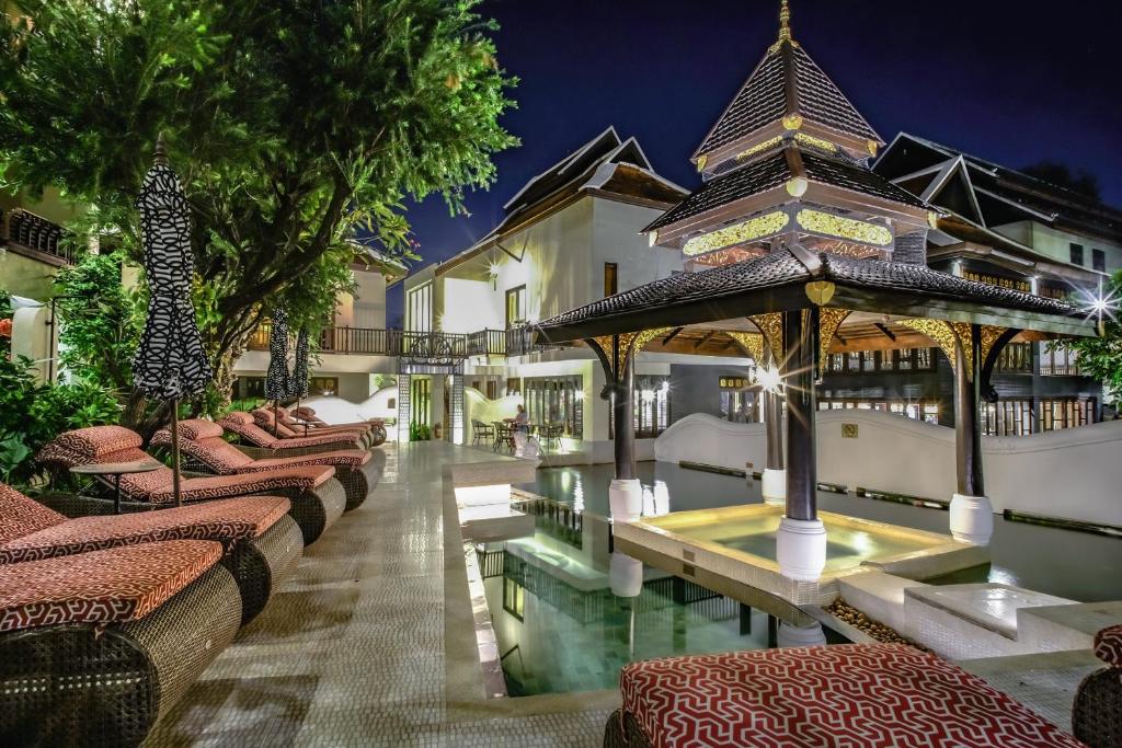 a hotel with a swimming pool and a resort at Puripunn Hideaway in Chiang Mai