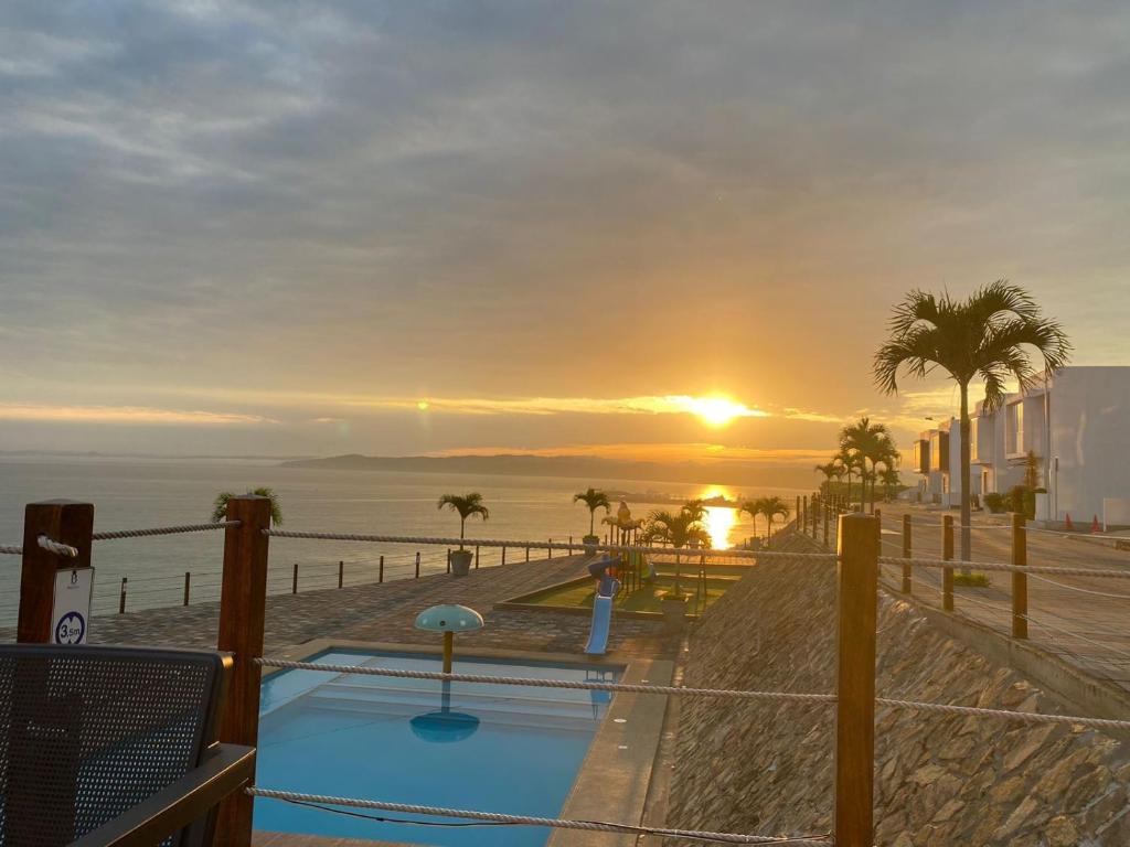 um pôr-do-sol sobre uma piscina junto ao oceano em Startfish house em Manta