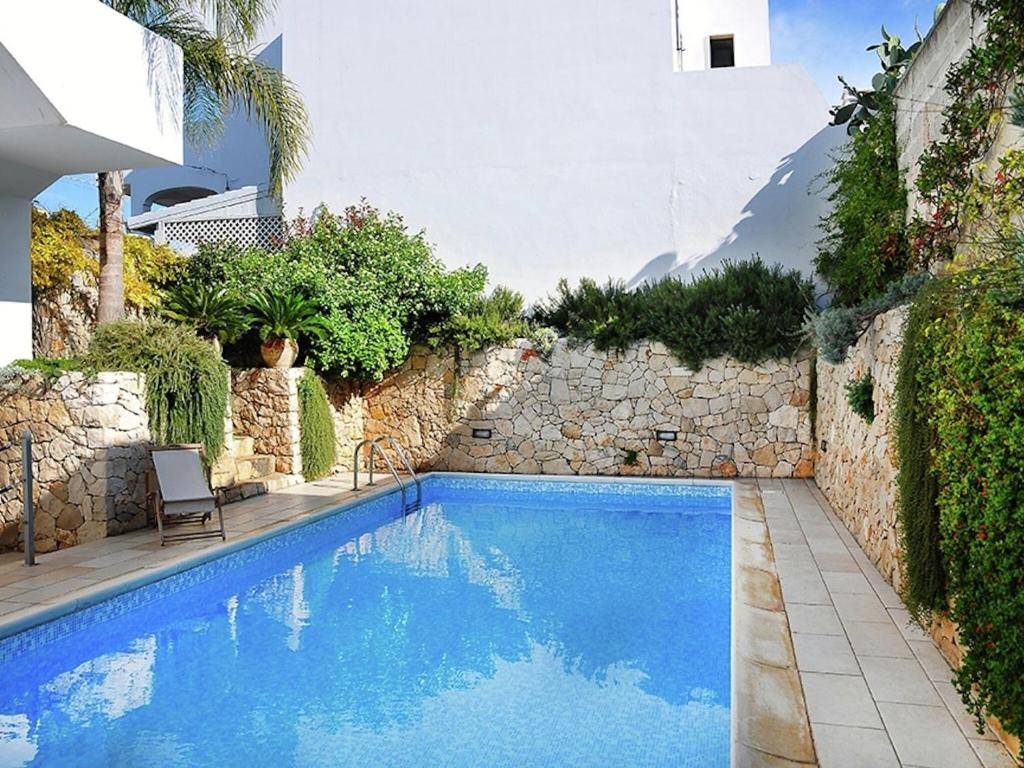uma piscina num quintal com uma parede de pedra em Holiday home 400 meters from the sea near Gallipoli em Nardò