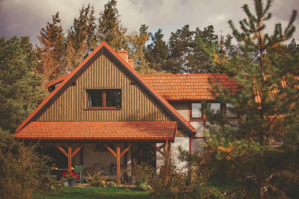 dom z pomarańczowym dachem i drzewami w obiekcie Dom W Trawie w Drawsku Pomorskim