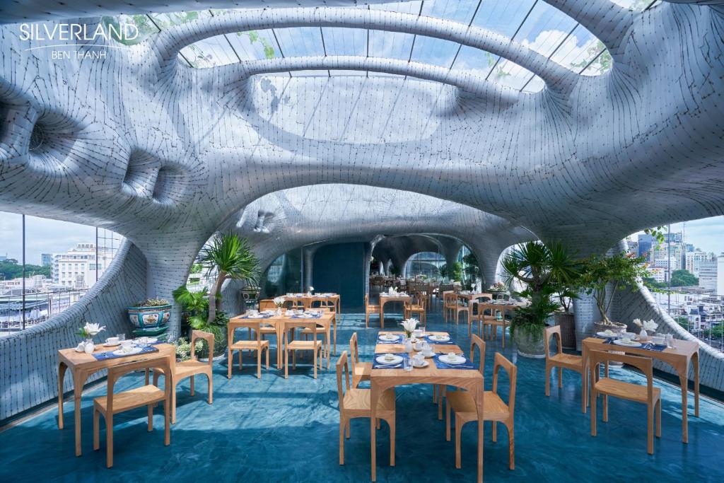 a restaurant with tables and chairs in a building at Silverland Bến Thành in Ho Chi Minh City