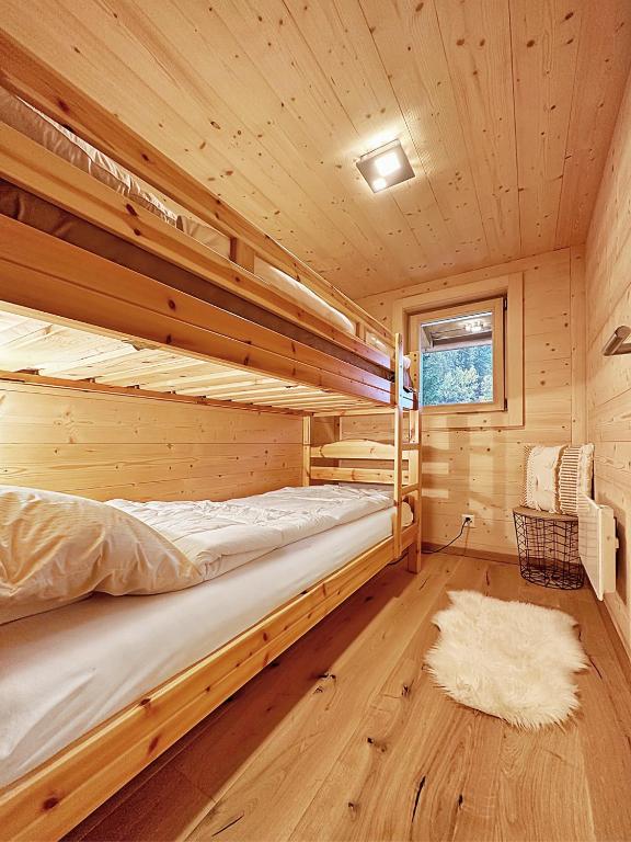 a bedroom with two bunk beds in a wooden cabin at Chalet a Didi - Alps Paradise - 4 Vallees in La Tzoumaz