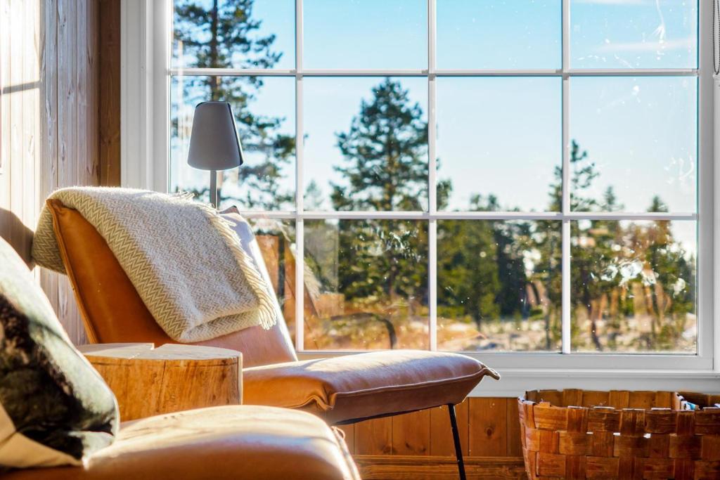 uma sala de estar com cadeiras e uma grande janela em Villa Budor 1.5 time fra Oslo em Nordset
