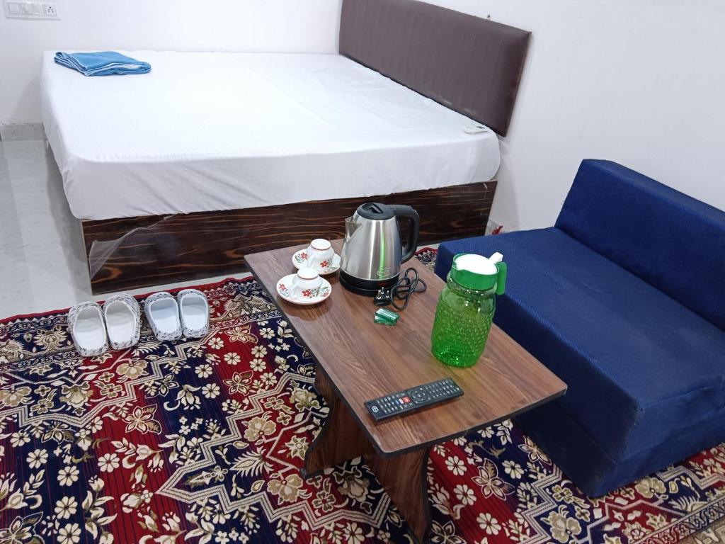 a small room with a bed and a coffee table at Hotel Balaji Residency in Udaipur