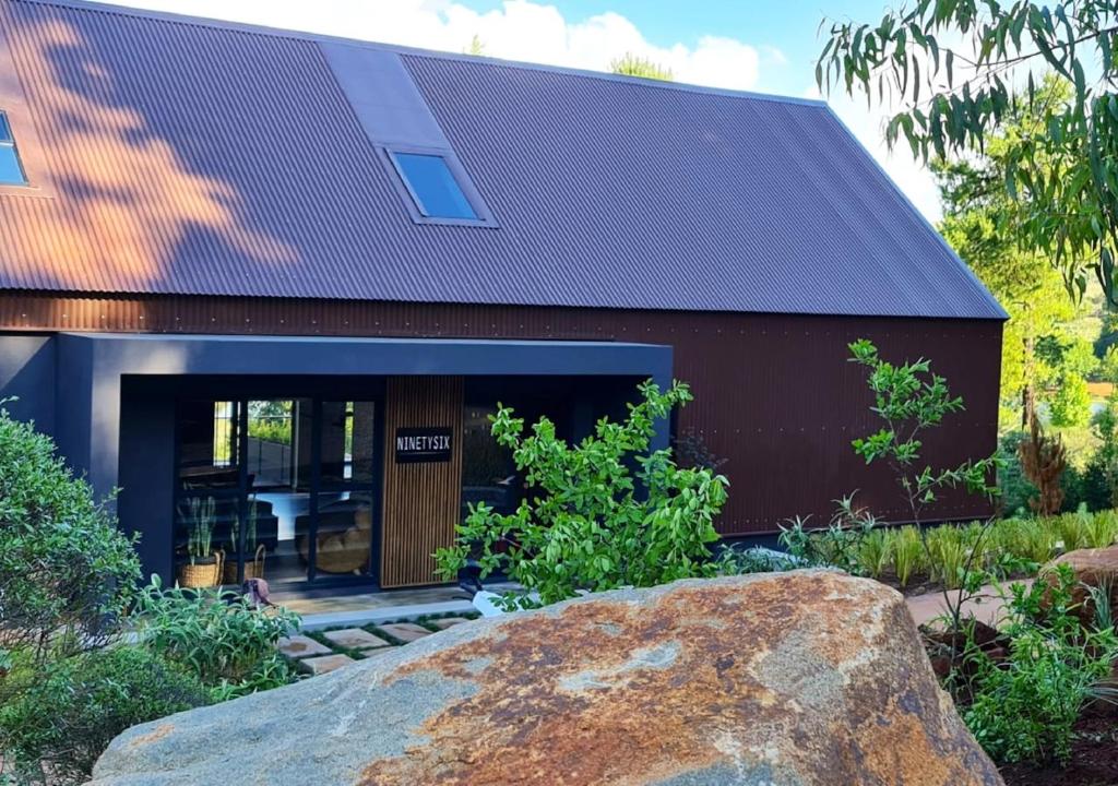 a house with a large rock in front of it at Walkersons 96 - NinetySix on Valley View in Dullstroom