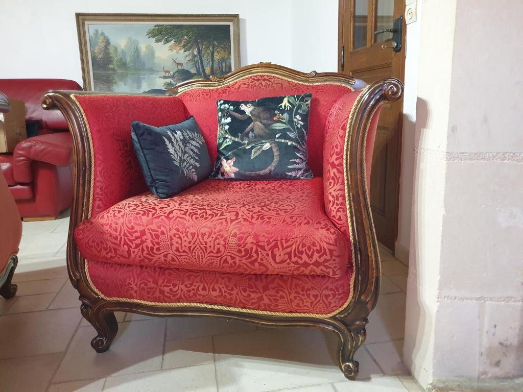 a red couch with pillows on it in a room at Grande maison bucolique Beauval Châteaux in Saint-Romain-sur-Cher