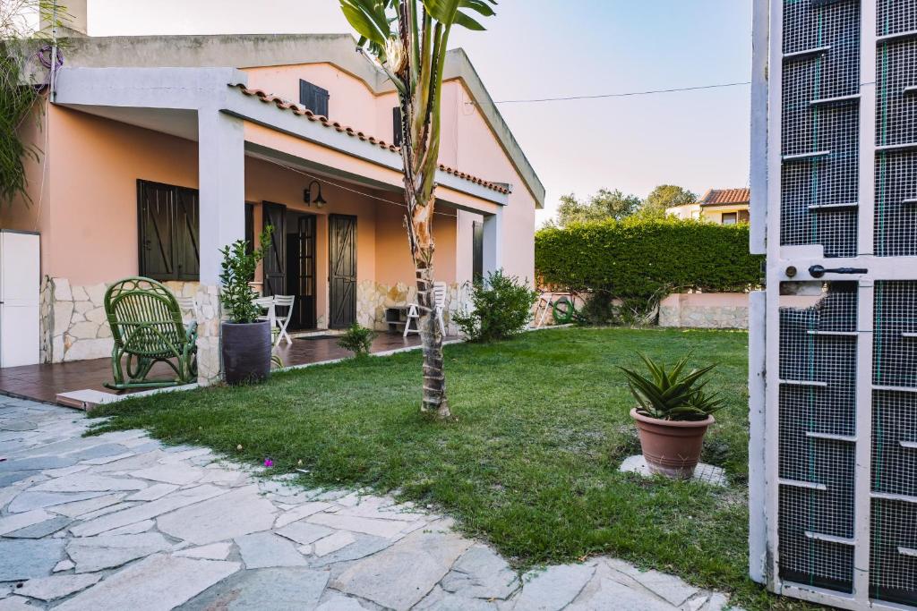 a house with a palm tree in the yard at Casa Vacanze Villa Carola in Quartu SantʼElena