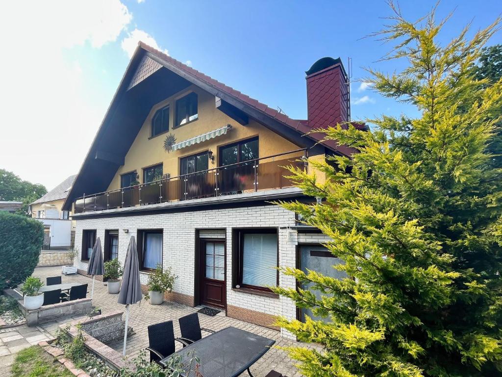 a house with a balcony and a tree at Ferienhus Baabe bei Familie Vergien in Baabe