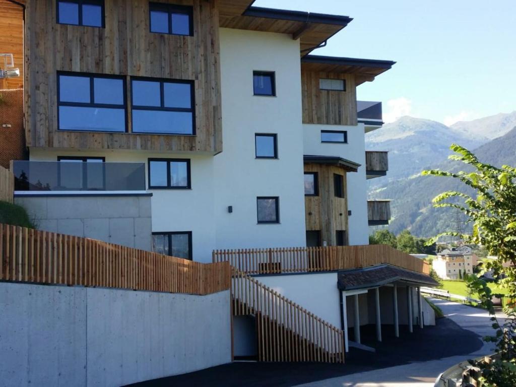 a house with a fence and mountains in the background at Inviting Apartment in Hart im Zillertal with Sauna in Hart im Zillertal