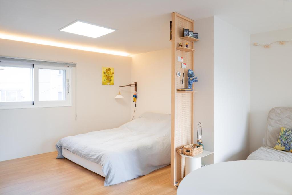 a bedroom with a bed and a window at Near Gangneung Station House in Gangneung