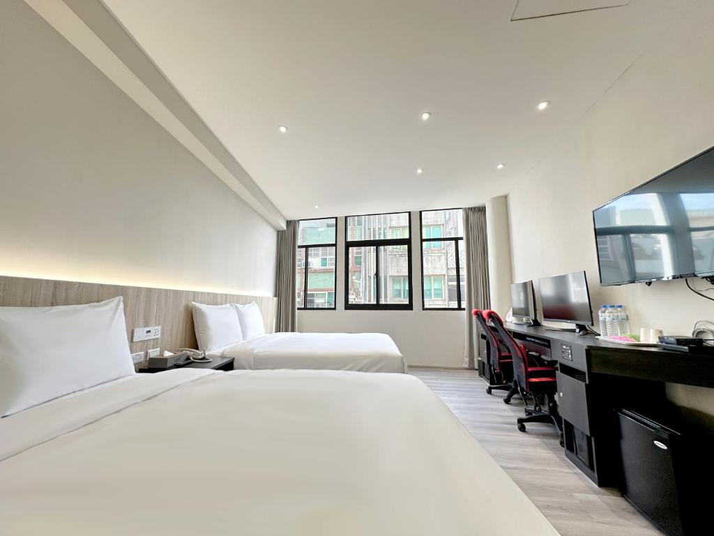 een hotelkamer met een groot bed en een bureau bij 福棧 Full.Inn in Dajia