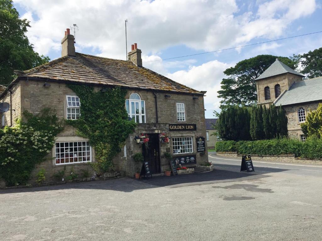 an old stone building with ivy on it at Old Coach House At The Golden Lion in Saint Johns Chapel