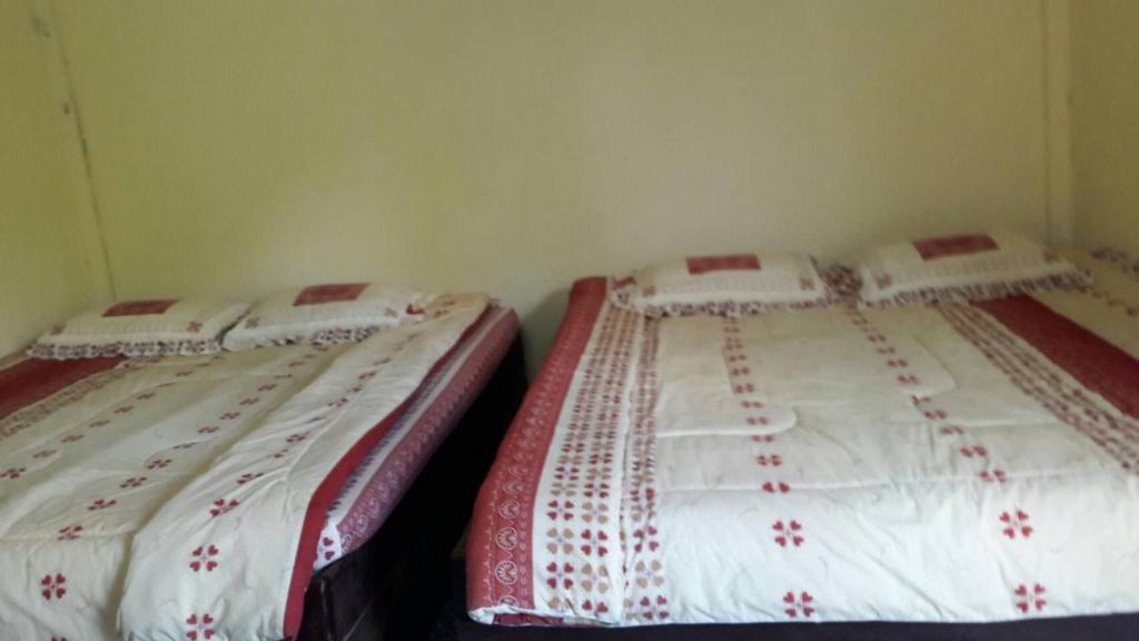 two beds sitting next to each other in a room at ทรัพย์ทอง การ์เด้น รีสอร์ท in Khao Kho