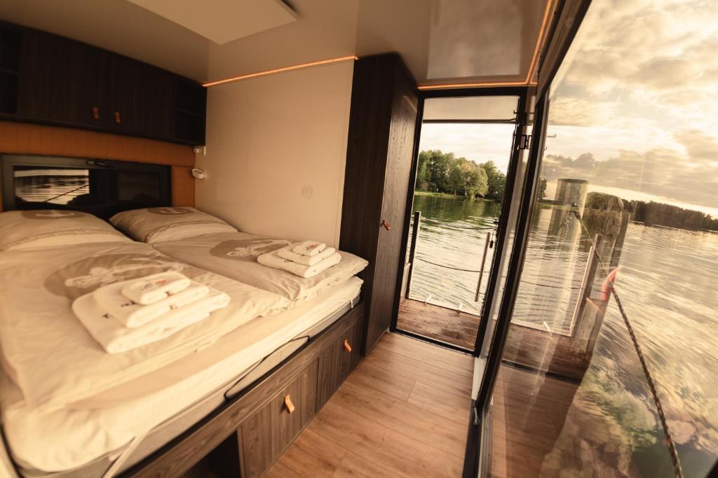 ein Schlafzimmer mit einem Bett und einem großen Fenster in der Unterkunft TRAUMZEITBOOT auf dem Scharmützelsee Bad Saarow in Bad Saarow