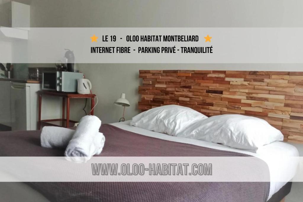 um poster de um quarto com uma cama com almofadas brancas em OLOO Habitat - Le19 - Parking Privé em Montbéliard