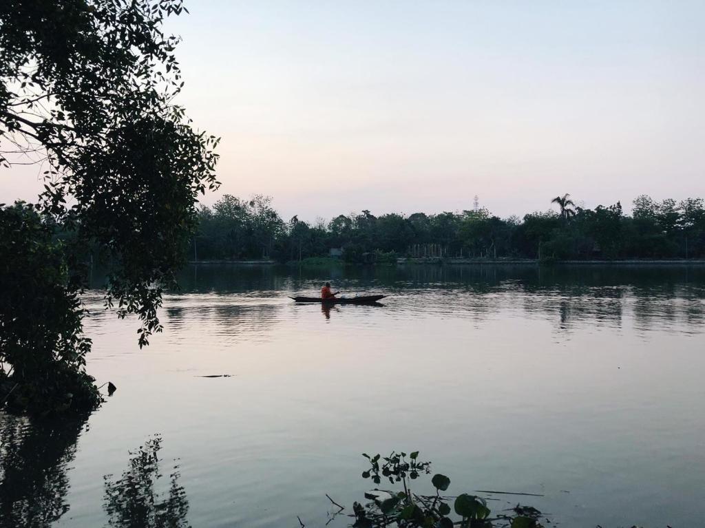 a person in a boat on a lake at ี เรือนปณาลี รีสอร์ท in Ban Khlong Sai Yok