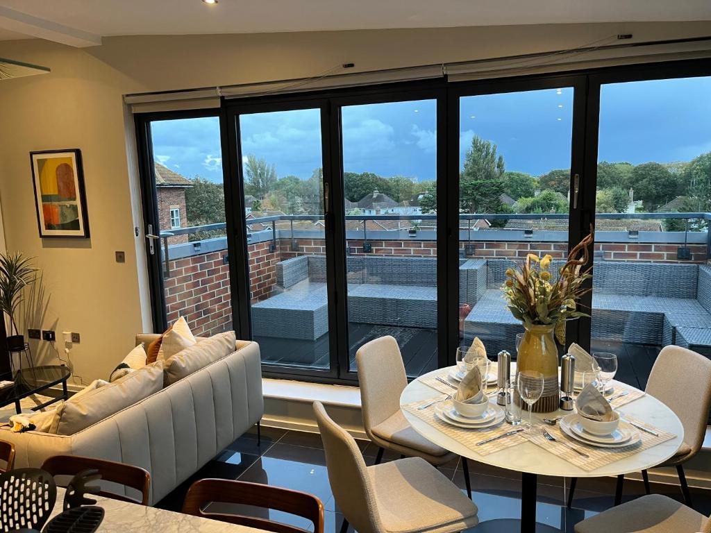 a dining room with a table and chairs and a large window at Stunning Luxury 3 Bed Penthouse Sleeps 2 to 6 in Hythe