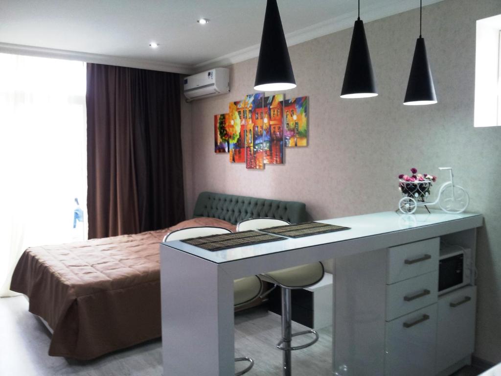 Sebi Apartment Batumi Towers في باتومي: غرفة نوم بسرير ومكتب مع كراسي