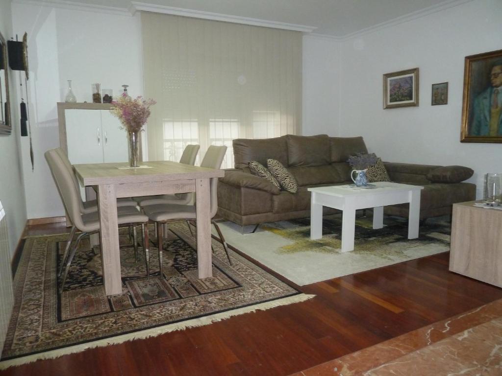 een woonkamer met een tafel en een bank bij Las Palmeras in Caldas de Reis