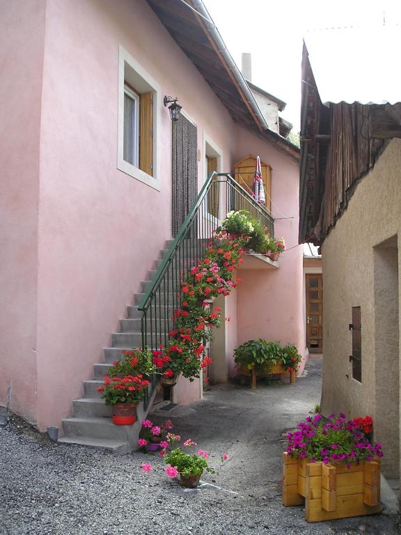 un escalier avec des fleurs en pots à côté d'un bâtiment dans l'établissement le clavette, à Vars