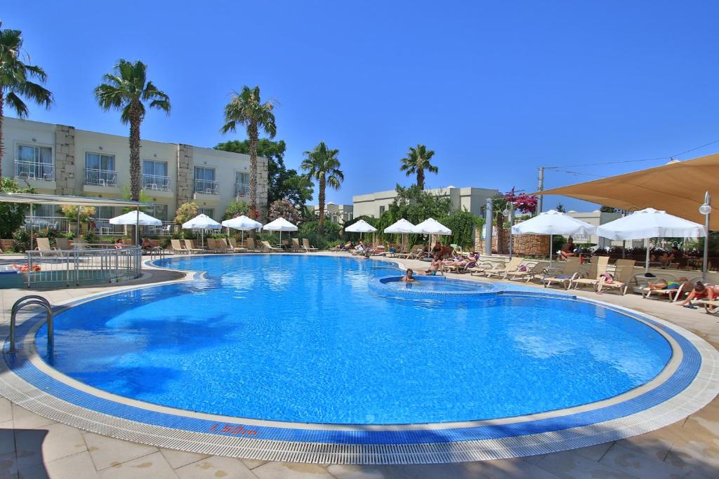 uma grande piscina com cadeiras e guarda-sóis num resort em Mandarin Resort & Spa em Bodrum City