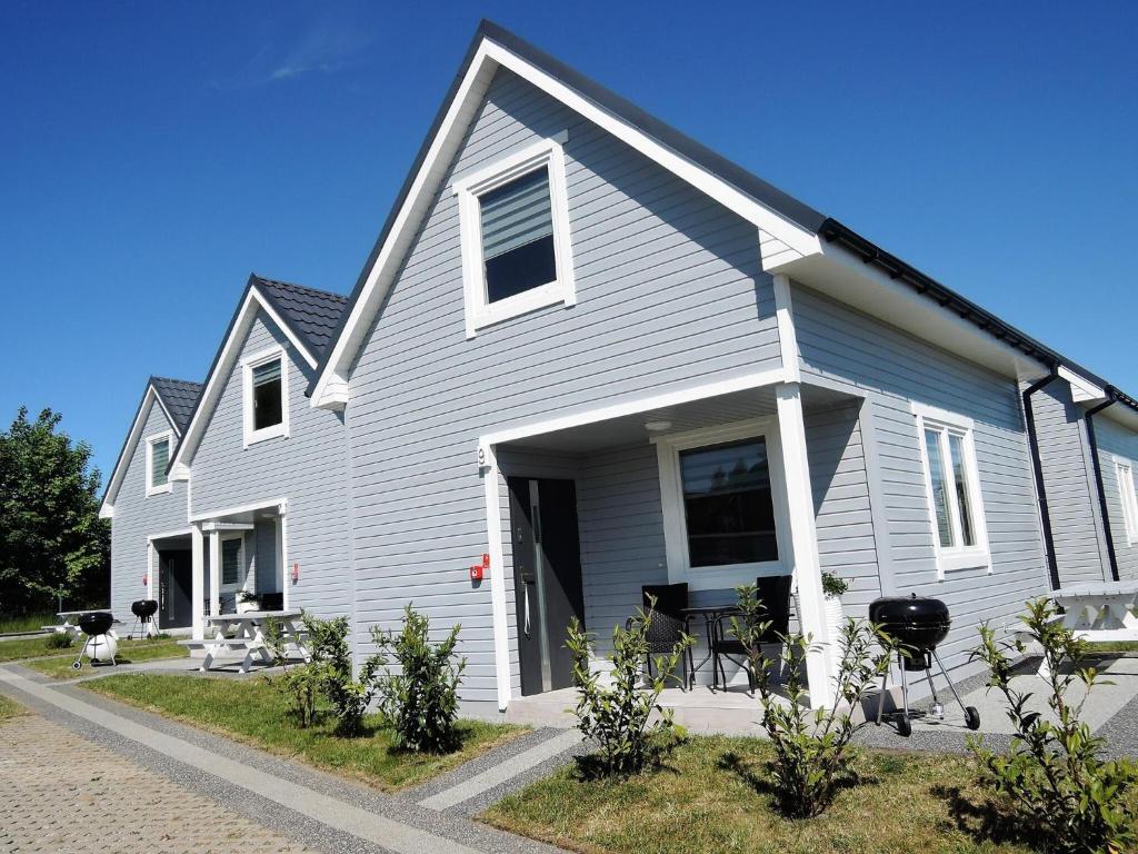 una casa gris con una mesa y sillas frente a ella en New comfortable houses for 6 people Niechorze en Niechorze