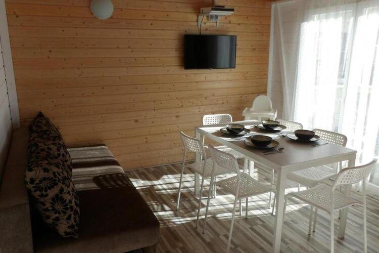 a dining room with a white table and chairs at Cottage for 4 people Ustronie Morskie in Ustronie Morskie