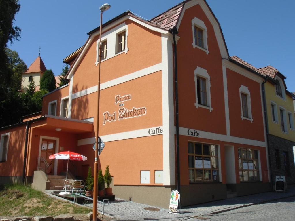 a building with a sign on the side of it at Penzion Pod Zámkem in Zruč nad Sázavou