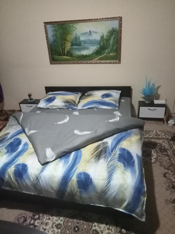 een slaapkamer met een bed met een blauw en wit dekbed bij Casa Aura.!! in Ocna-Mureşului
