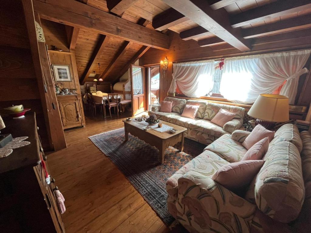 ein Wohnzimmer mit einem Sofa und einem Tisch in der Unterkunft Mansarda di pregio in San Vito di Cadore