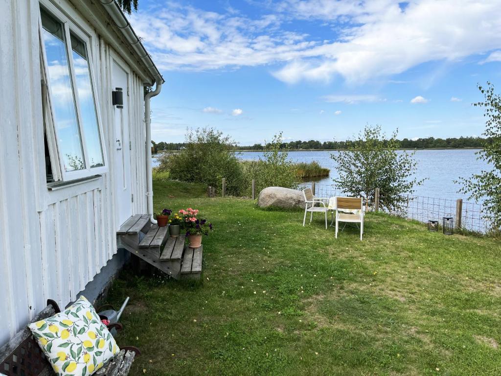 uma casa com um quintal com vista para a água em Cozy cottage located on a nice sea plot on Boholmarna outside Kalmar em Kalmar